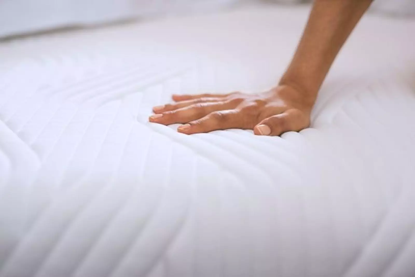 A hand on a Tempur mattress