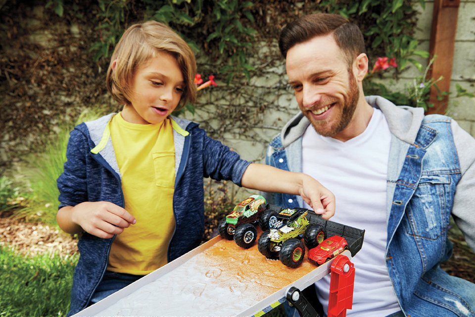 A father and son playing with hot wheels monster truck downhill race and go.