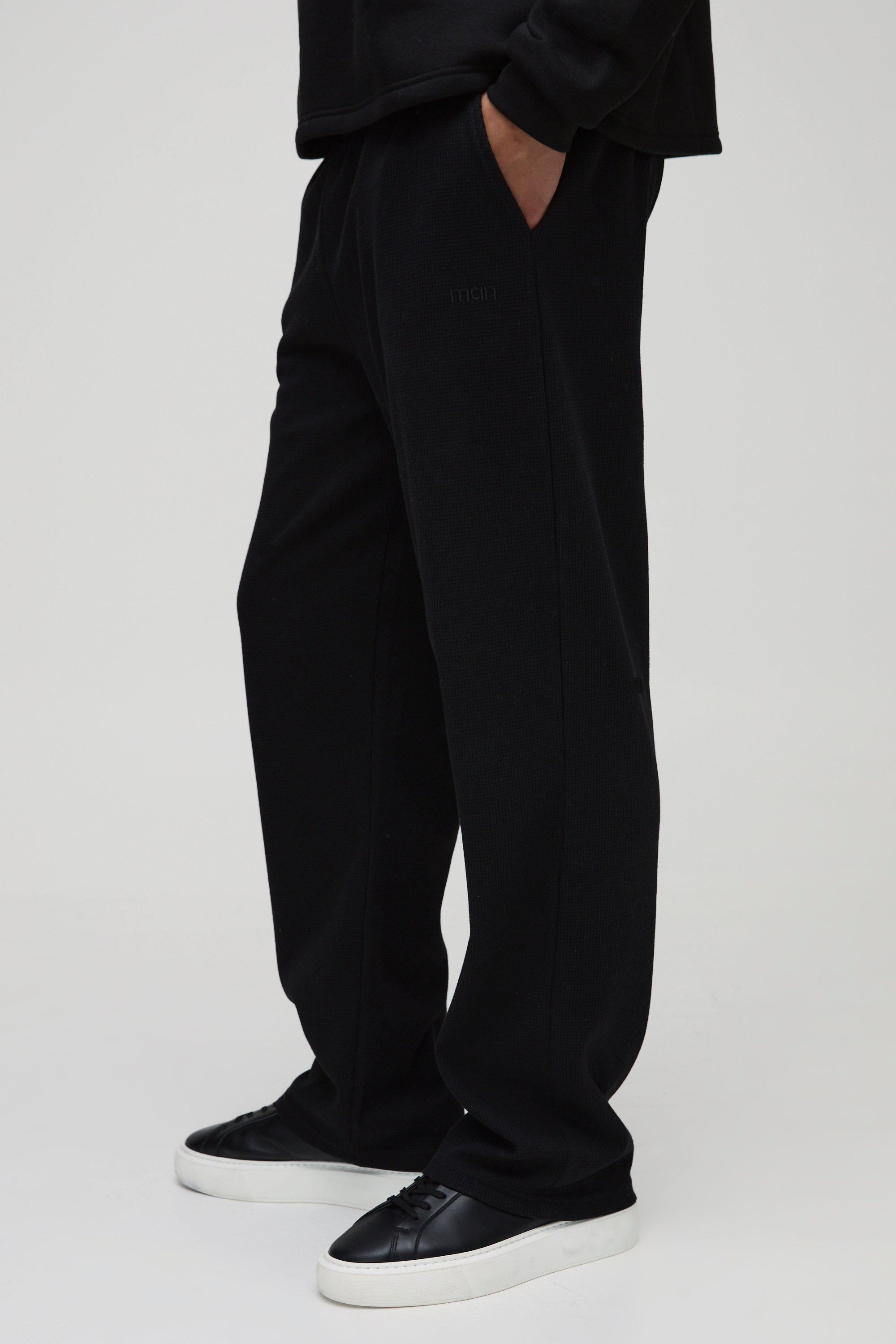Pantaloni tuta dritti con ricamo Man e trama a nido d'ape, Nero