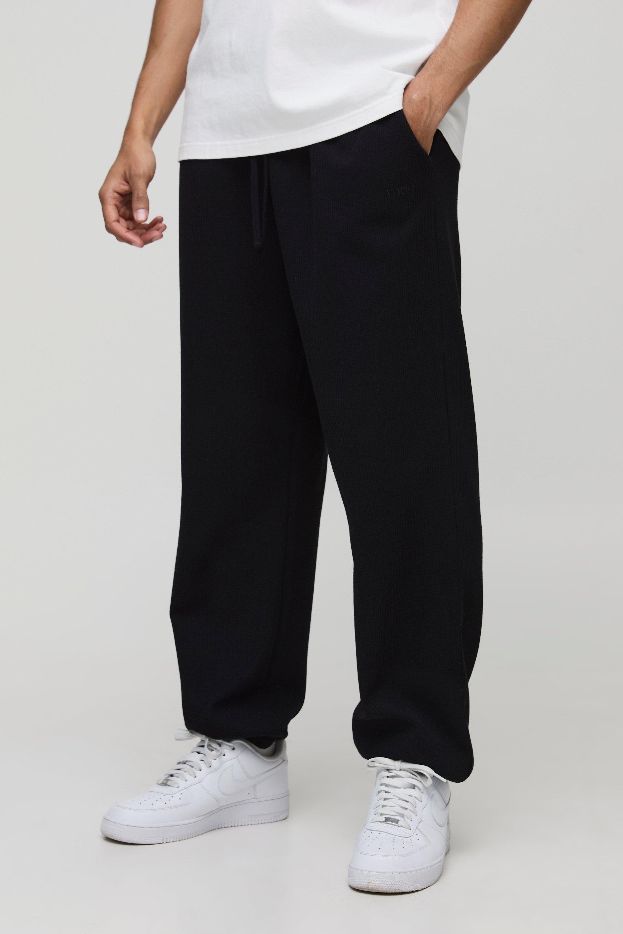 Pantaloni tuta oversize Man con ricami a nido d'ape e polsini alle caviglie, Nero