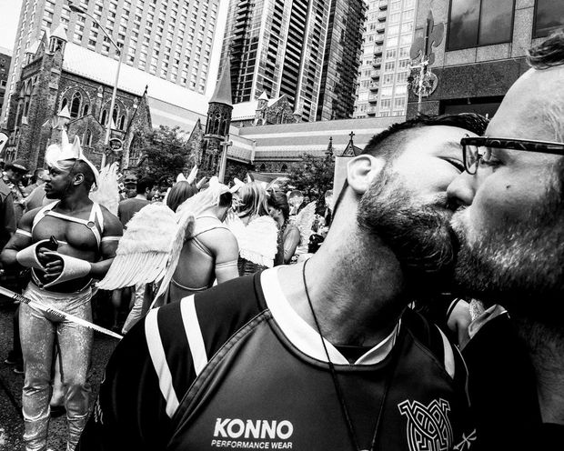 John-Paul Markides (left) kisses his partner Muddy York teammate Kasimir Kosakowski during the Pride Toronto parade.