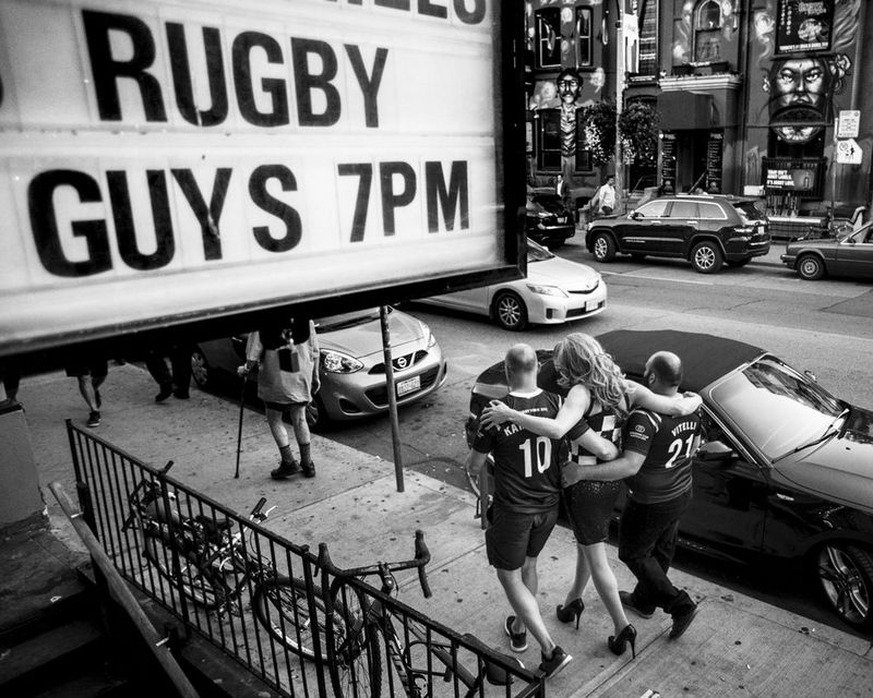 Muddy York RFC’s captain Jimmy Karttunen (left) and teammate Carlo Vitelli (right) walk with drag queen Demanda Tension along Church Street in Toronto’s gay village.