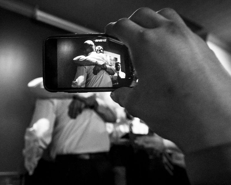 Muddy York Rugby Football Club player Andrew Hsueh films an emotional moment between the team’s president John Jeffery and director of recruitment Ian Gibb during the awards ceremony at the team’s end-of-season banquet, in Toronto, Canada.