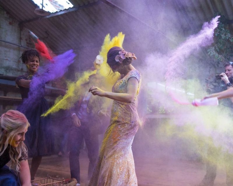 fun action picture of two woman pouring powder paint on each other