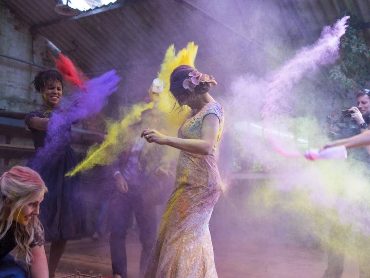 fun action picture of two woman pouring powder paint on each other