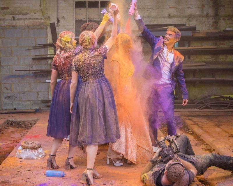 Group of people pouring coulored powder on a woman.