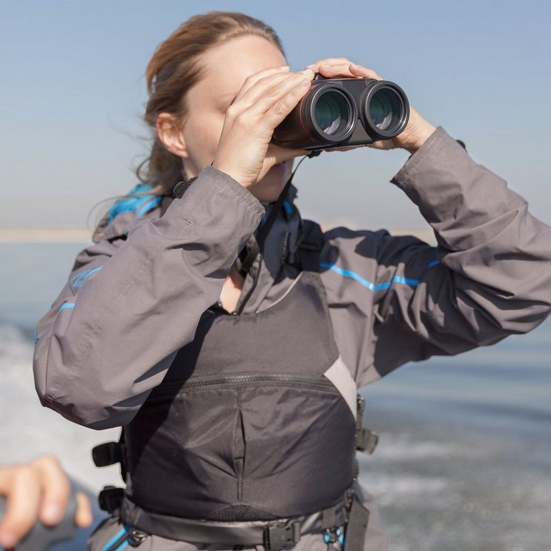 Canon 10x42L IS WP Fernglas Frau, die das Fernglas im Freien verwendet