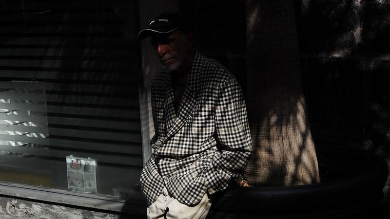 Subject candid on the streets of Italy wearing a blue chequered blazer.