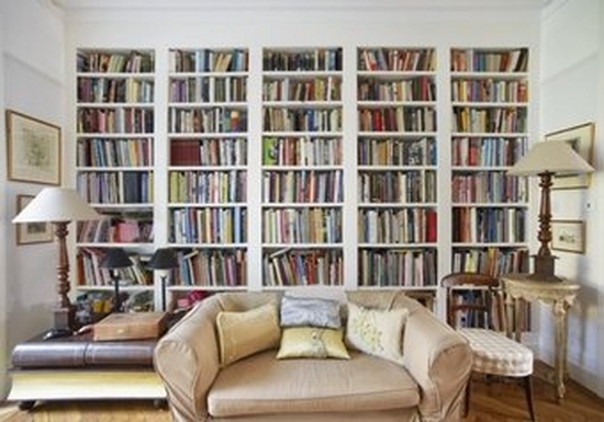 Living room with a colourful bookcase across the back wall