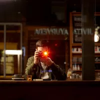 Canon EOS M6 + EF-M 18-150mm IS STM Lens- Black A Man Taking a Photo in a Dark Café
