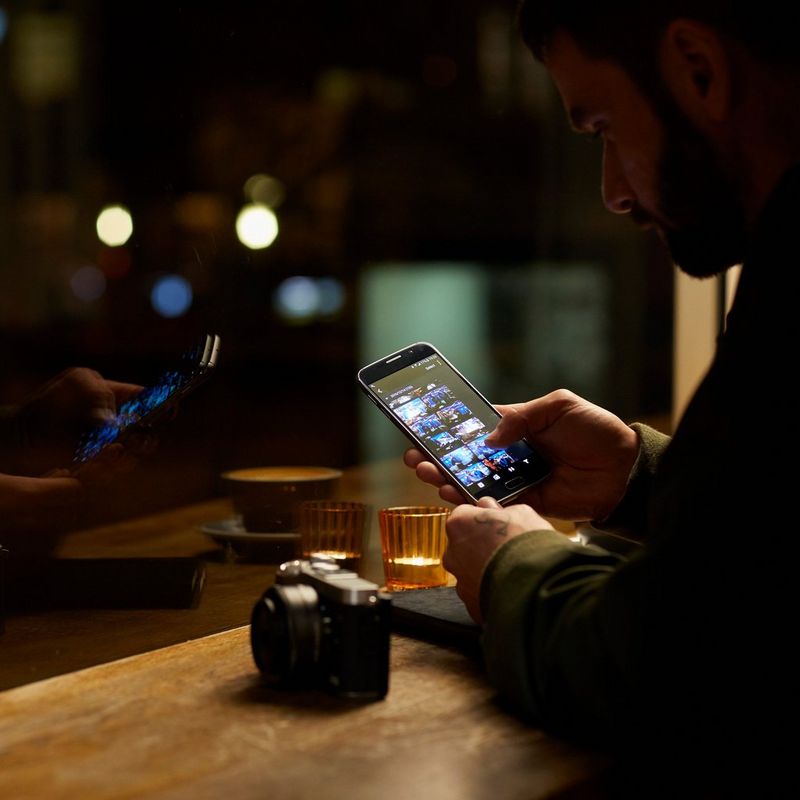 Canon EOS M6 + objetiva EF-M 15-45mm IS STM preta 0 Um homem a rever as imagens no seu smartphone