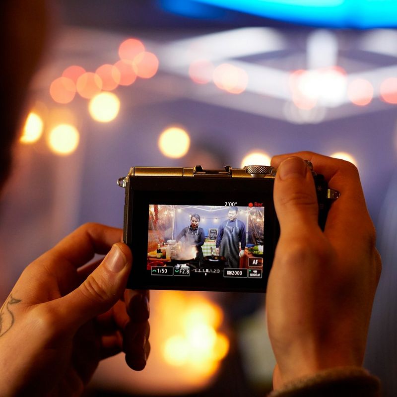 Canon EOS M6 Silver + EF-M 15-45mm IS STM Lens + EF-M 55-200mm IS STM Lens Graphite Shooting a Video at a Food Stall