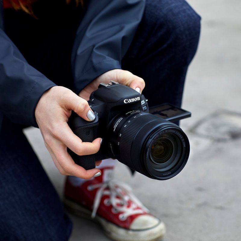 Canon EOS 77D + EF 18-55mm IS STM Lens + Backpack + Spare Battery Camera Holding With Two Hands And Photo Being Taken