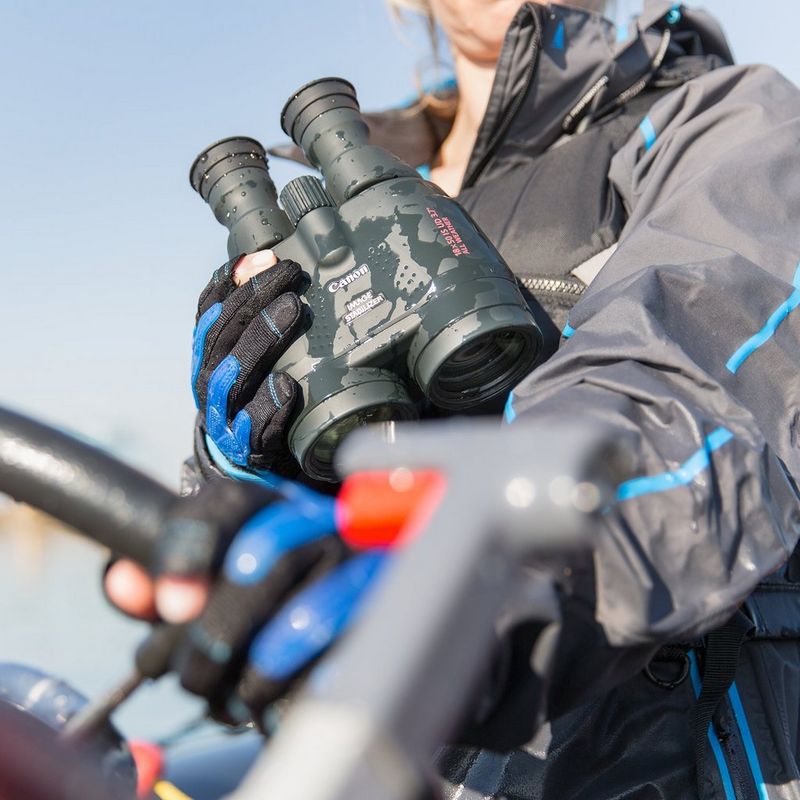 Canon 18x50 IS Binoculars Woman Holding Binoculars that Have Been Rained On to Show the Waterproof Aspect