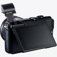 Canon EOS M100 negra + objetivo EF-M 15-45mm f/3.5-6.3 IS STM negro Producto Vista diagonal posterior con el flash incorporado y la pantalla abatible