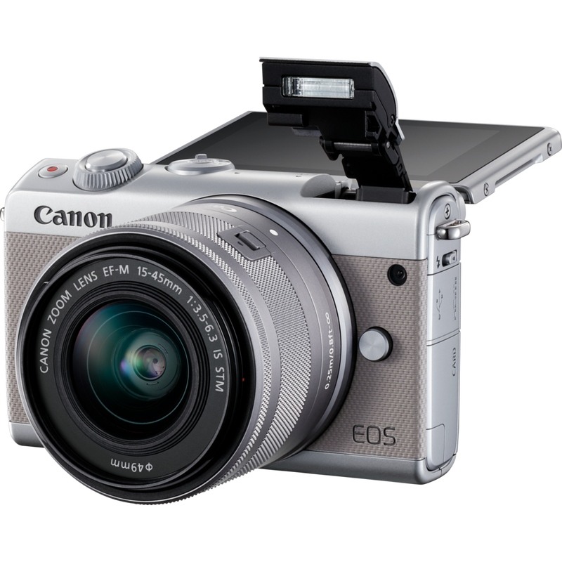 Canon EOS M100 Grey + EF-M 15-45mm f/3.5-6.3 IS STM Lens Silver Product Diagonal View with Built-in Flash and Tilted Screen