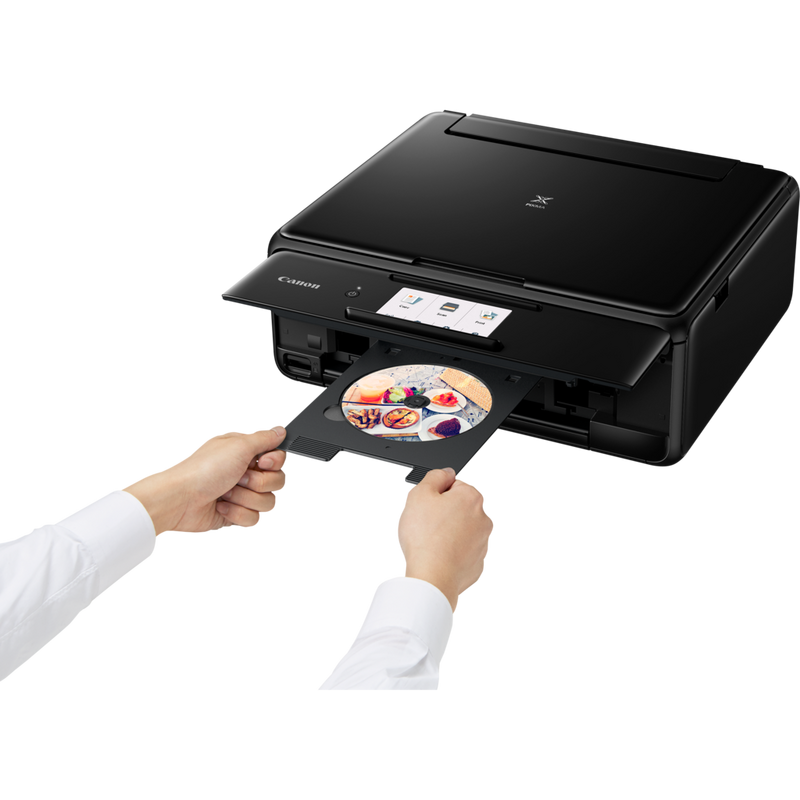 Canon PIXMA TS8150 - Black Product Front Slant View With A Person Inserting A Compact Disc