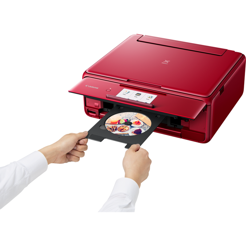 Canon PIXMA TS8152 – czerwona Produkt Widok z przodu pod skosem – osoba wkłada płytę kompaktową