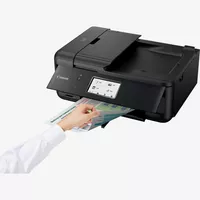 Canon PIXMA TR8550 Produkt Schrägansicht von vorne mit einer Person, die die Druckausgabe prüft
