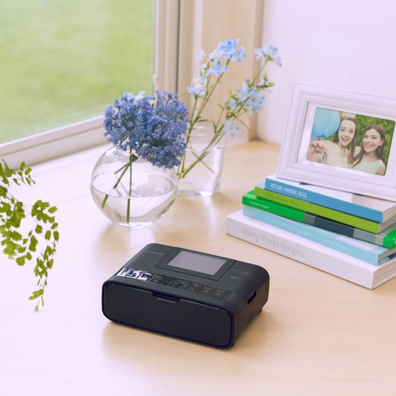 Canon SELPHY CP1300 – Schwarz Drucker und Bilderrahmen auf dem Schreibtisch