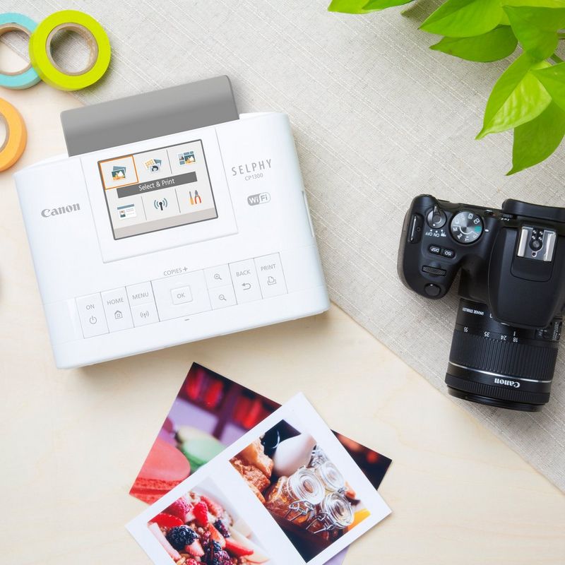 Canon SELPHY CP1300 Colour Portable Photo Printer - White Printer on Desk with prints and camera