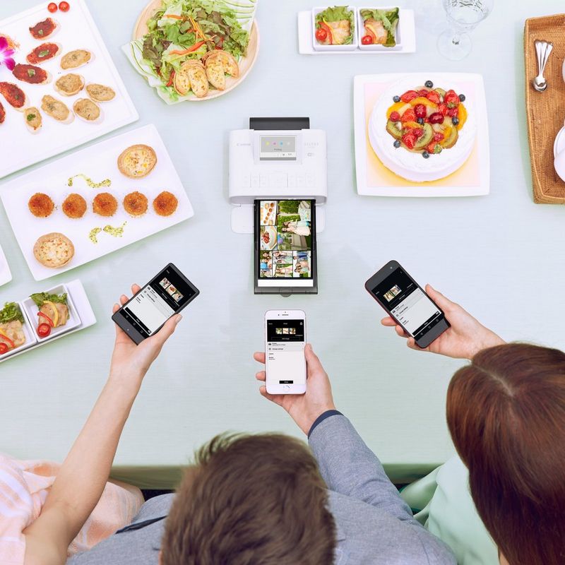 Canon SELPHY CP1300 - Rose 3 personnes utilisant l'imprimante avec des aliments en arrière-plan
