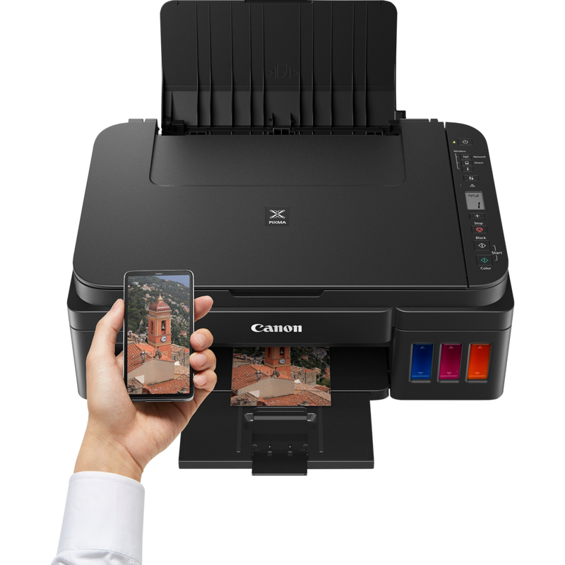 Stampante Canon PIXMA G3510 Su un tavolo di fronte a una persona che usa lo smartphone