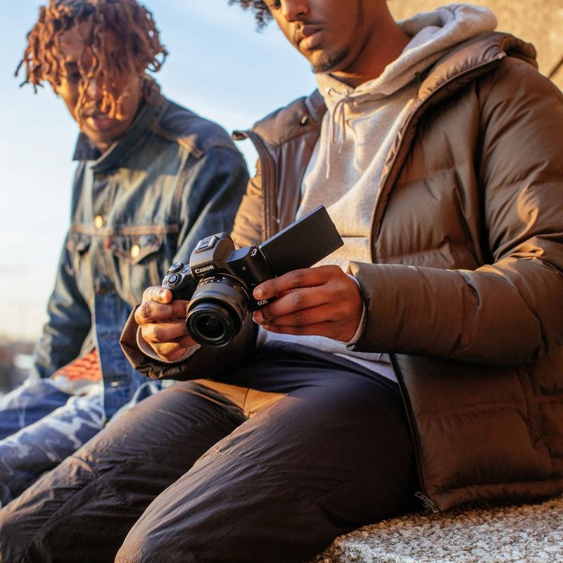 Canon EOS M50 für Wechselobjektive im Videokonferenz-Kit 0 Männer beim Durchschauen der Bilder auf dem Kameradisplay