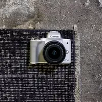 Canon EOS M50 Blanc + objectif EF-M 15-45mm STM Argent 0 L'appareil photo sur un tapis
