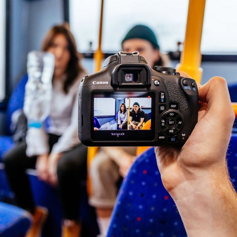 Canon EOS 2000D + Objectif EF-S 18-55mm IS II + Objectif 50mm STM Homme tenant un appareil photo et prenant une photo