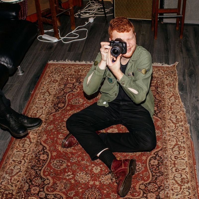 Canon EOS 2000D + EF-S 18-55mm IS II-objektiv + rygsæk + SD-kort  Mand, der holder kamera, med produkt set forfra