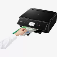 Multifonction 3-en-1 Canon PIXMA TS6250, Noir Produit Vue avant inclinée, montrant une personne en train d'examiner le tirage