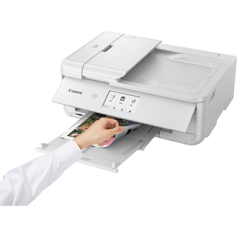 Canon PIXMA TS9551Ca trådløs alt-i-én-inkjet-fotoprinter til A3, hvid Produkt Set skråt forfra med en person, der tjekker printet