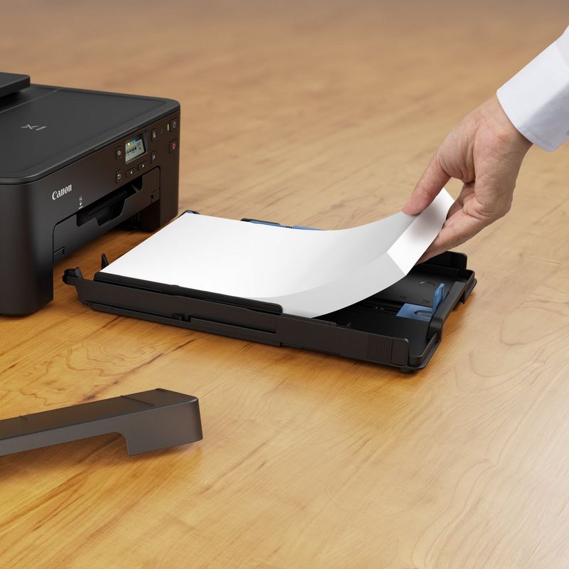 Canon PIXMA TS705 Inkjet Printer Product Slant View With A Person Adding Paper To The Paper Feeder Tray