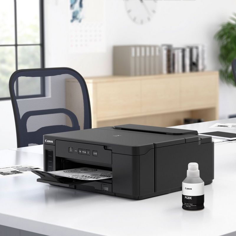 Canon PIXMA GM2040 Mono Refillable MegaTank Printer Kept On A Table With Paper Tray Out and Beside the Black Ink Bottle