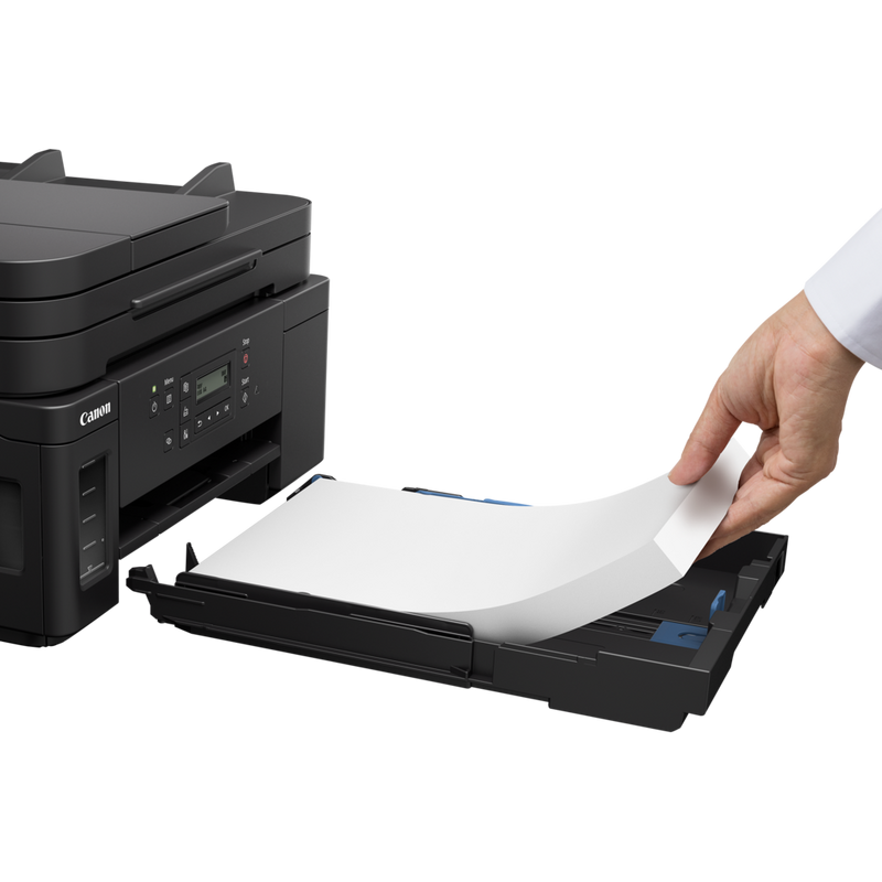 Canon PIXMA GM4040 Refillable MegaTank Inkjet Printer Product Slant View With A Person Adding Paper To The Paper Feeder Tray