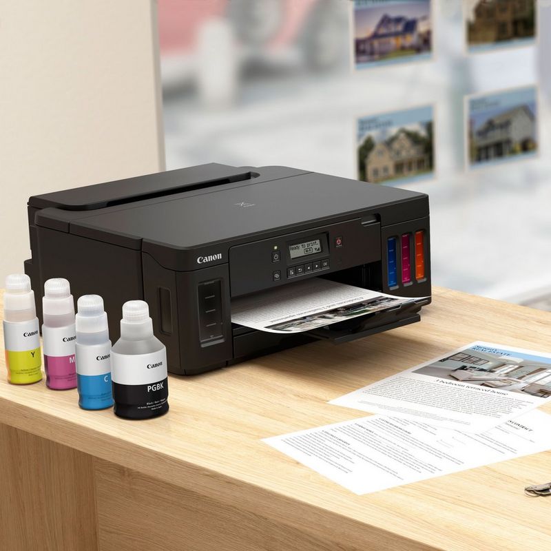Canon PIXMA G5050 Refillable MegaTank Printer Kept On A Table With Paper Tray Out Along With Ink Bottles