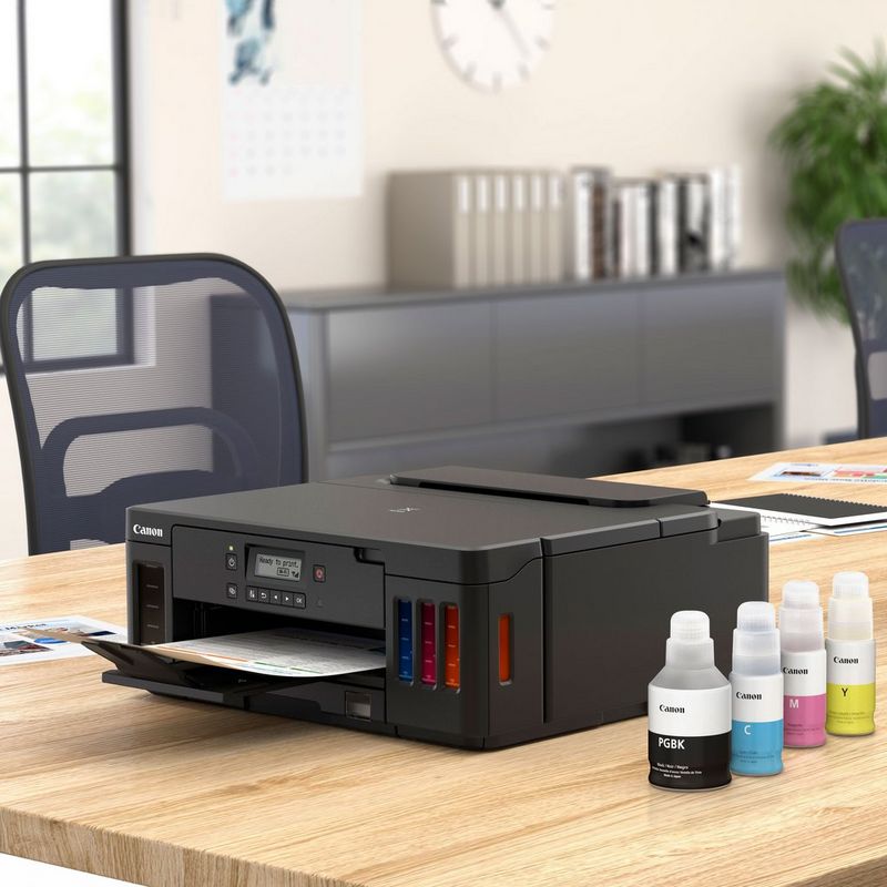 Canon PIXMA G5050 Refillable MegaTank Printer Kept On A Table With Paper Tray Out Along With Ink Bottles
