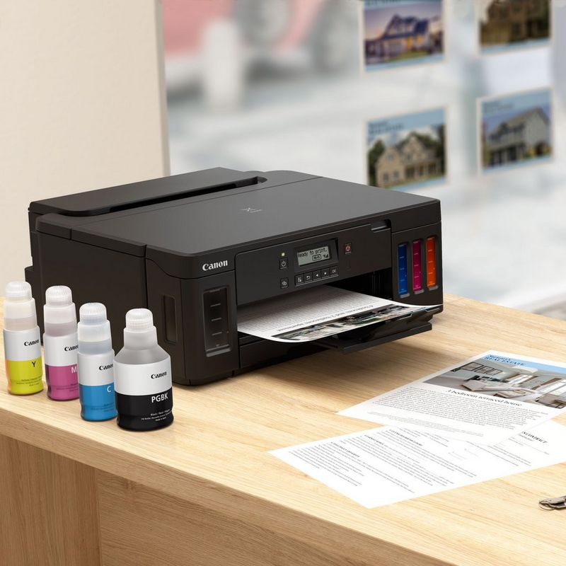 Canon PIXMA G5040 Refillable MegaTank Printer Kept On A Table With Paper Tray Out Along With Ink Bottles
