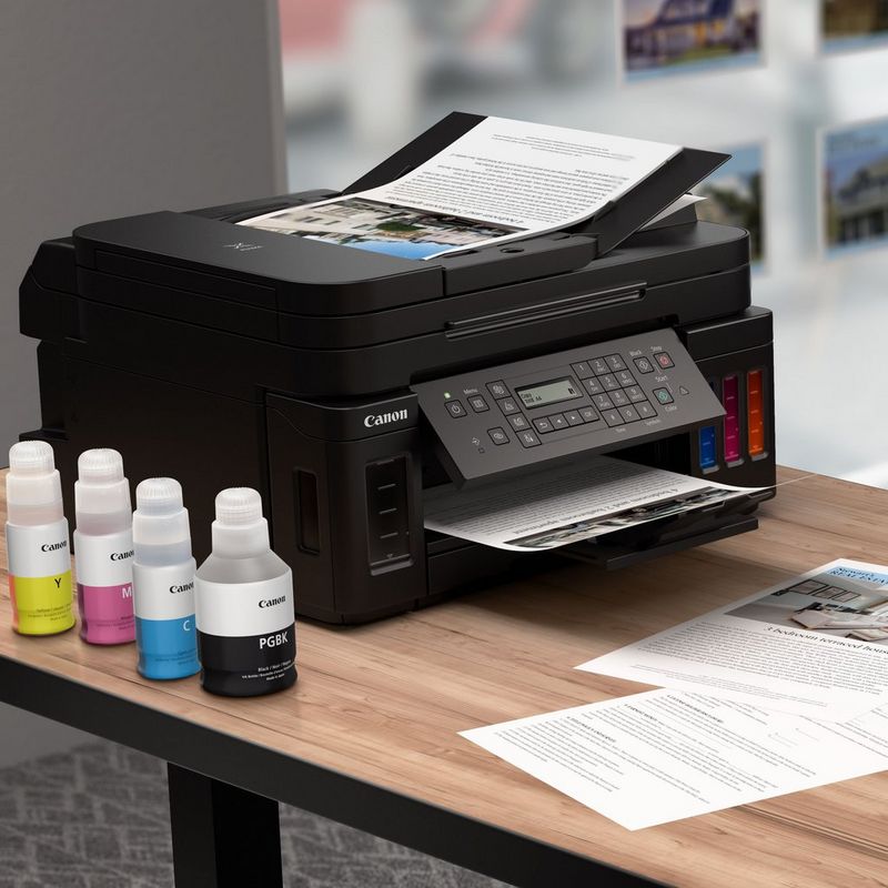 Canon PIXMA G7050 Refillable MegaTank Inkjet Printer Kept On A Table With Paper Tray Out Along With Ink Bottles