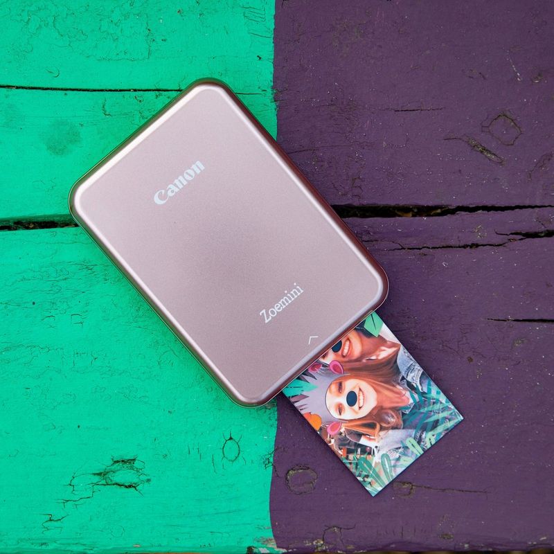 Impresora fotográfica portátil Canon Zoemini, oro rosa Impresora con impresiones en un escritorio colorido