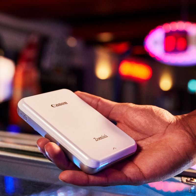 Impresora fotográfica portátil Canon Zoemini, blanco Una mano sostiene una impresora