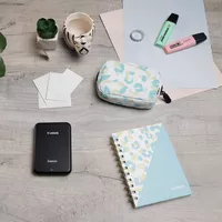 Imprimante photo couleur portable Canon Zoemini, noire + agenda + étui Imprimante installée sur un bureau avec une tasse