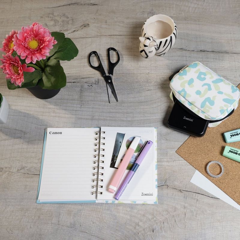 Canon Zoemini Portable Colour Photo Printer, Black + Diary + Pouch Printer positioned on Desk and Scissors