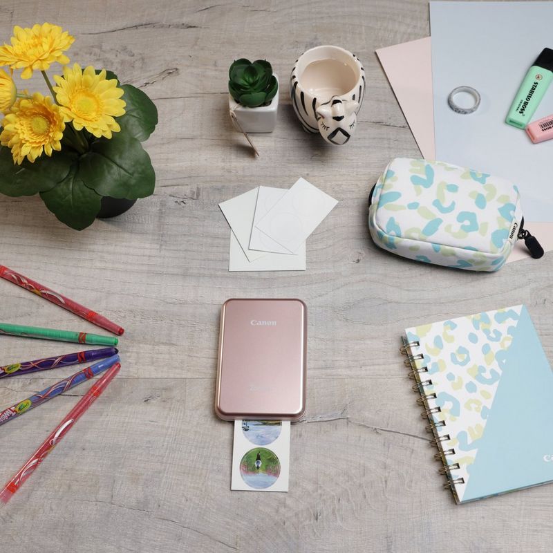 Imprimante photo couleur portable Canon Zoemini, rose doré + agenda + étui Imprimante installée sur un bureau avec des stylos