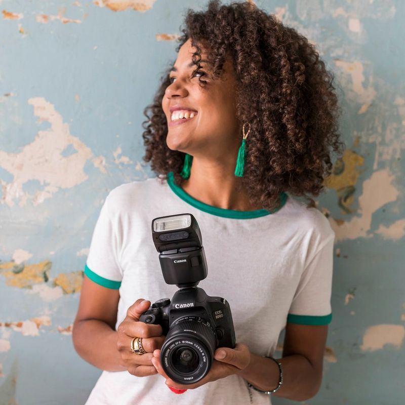 Canon Speedlite EL-100 Blitzgerät 0 Kamera mit Blitz in der Hand einer Frau