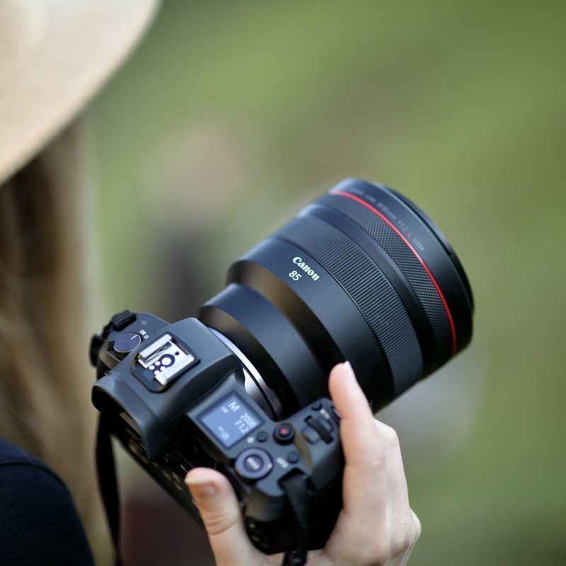 Canon RF 85mm F1.2L USM Objektiv Eine Frau, die eine Kamera vor ihr Gesicht hält