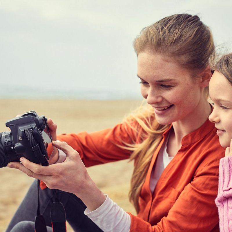 Canon EOS 250D Gehäuse, Schwarz Frau, die eine Kamera hält