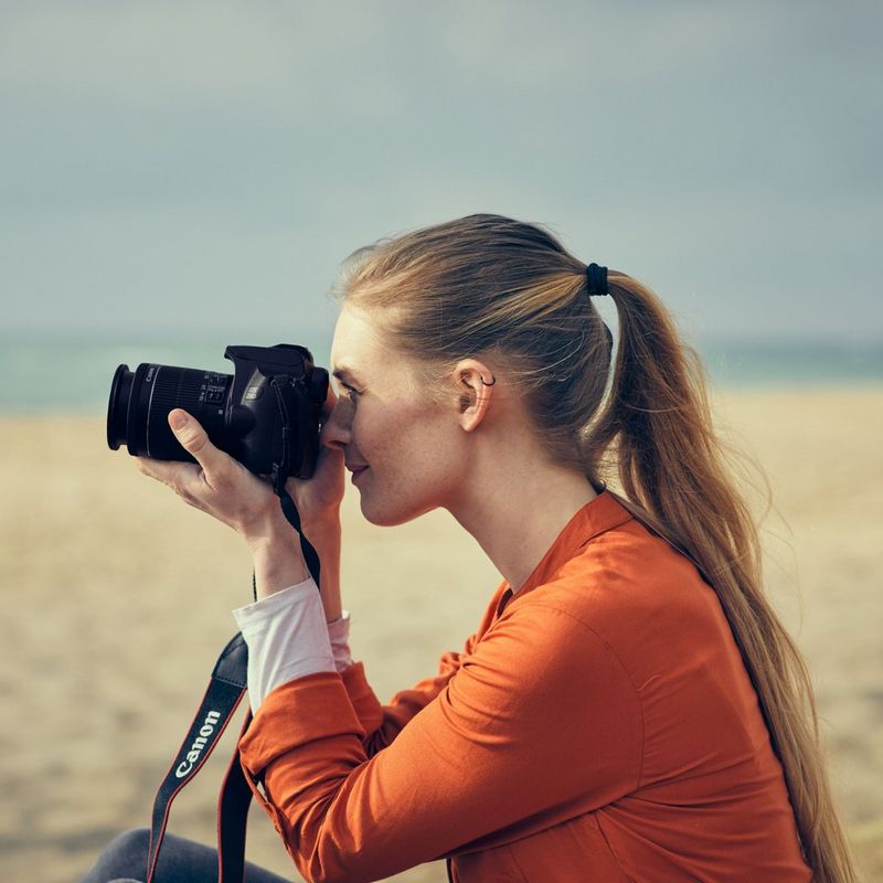 Canon EOS 250D Gehäuse, Schwarz Frau, die eine Kamera hält, um ein Foto zu machen