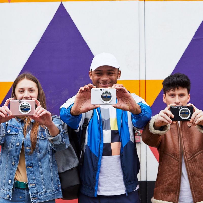 Cámara impresora instantánea Canon Zoemini S, negro mate 3 personas posando con la impresora